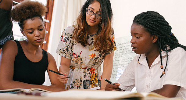 Young people of color working around table